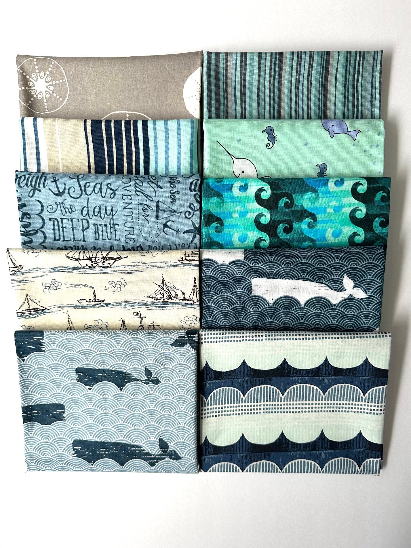 a collection of fabric swatches with various patterns and designs, including nautical and marine-themed patterns.