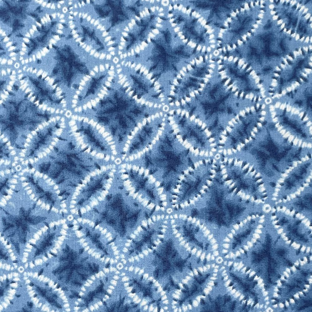 a close-up view of a fabric with a repeating pattern of blue and white circles and lines, creating a visually striking and intricate design.