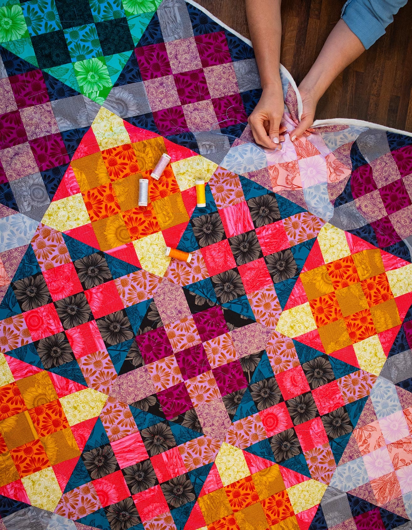a woman is working on a colorful quilt