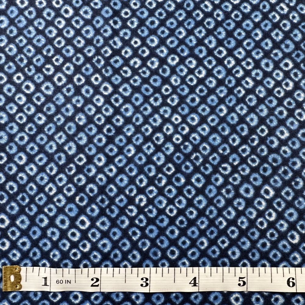 a close-up view of a fabric with a blue and white diamond pattern, and a ruler is placed in front of it to indicate the fabric's length.