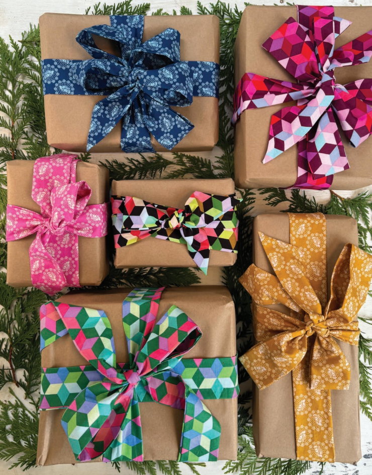 a collection of six wrapped gifts, each adorned with a colorful geometric ribbon bow. The bows come in various shades of blue, pink, and yellow, adding a festive touch to the presents. The gifts are arranged on a white surface, with some overlapping each other, creating a visually appealing display.