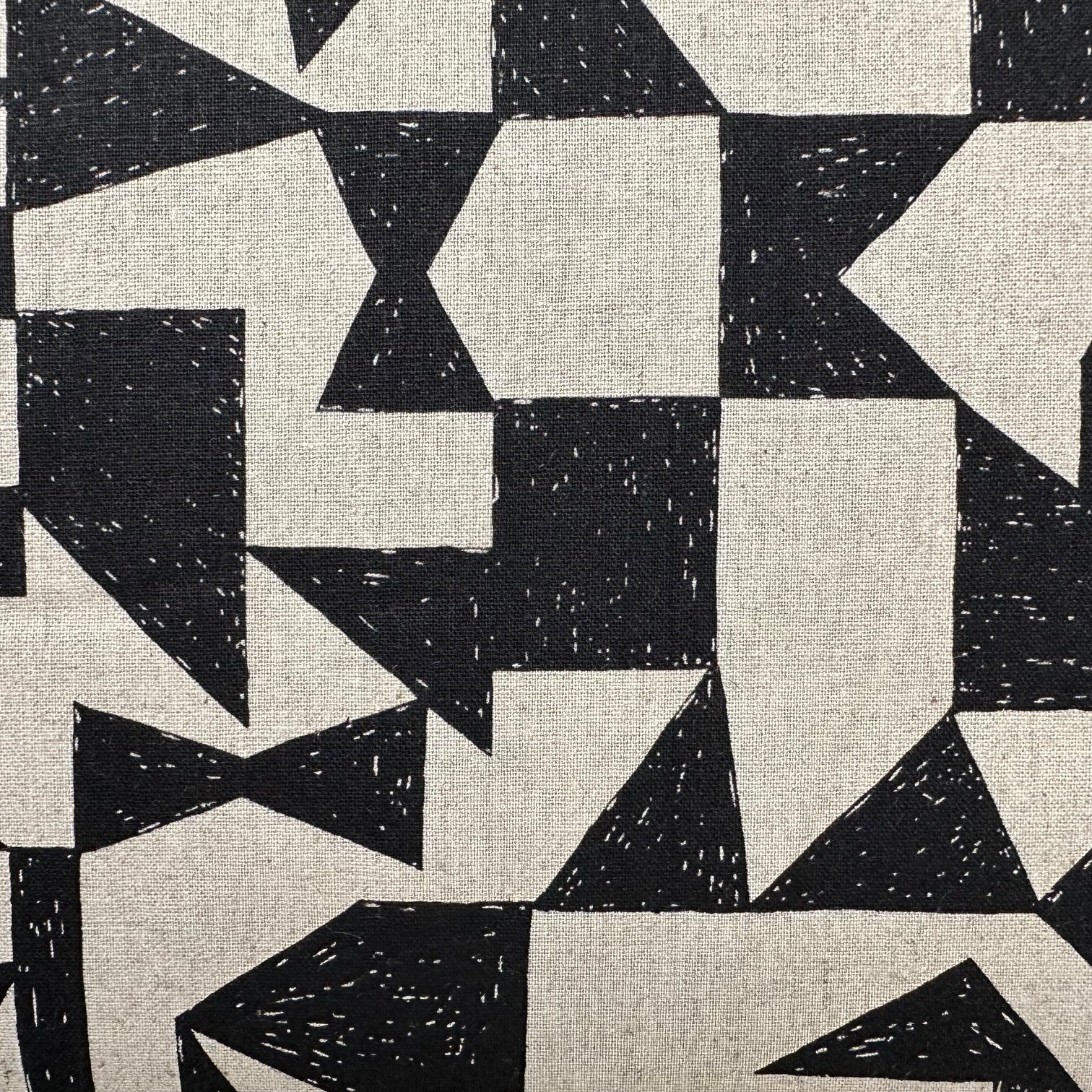 a close-up view of a black and white geometric pattern composed of various shapes and sizes of triangles and rectangles.