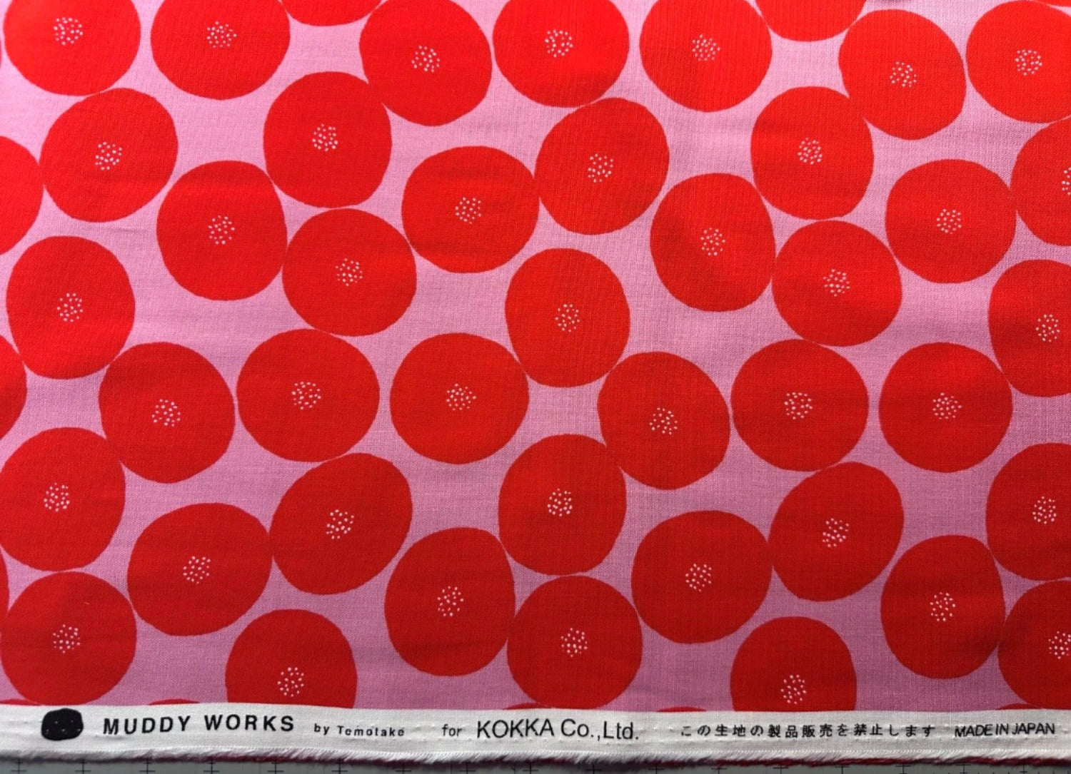 a repeating pattern of red circles with white dots on a pink background.