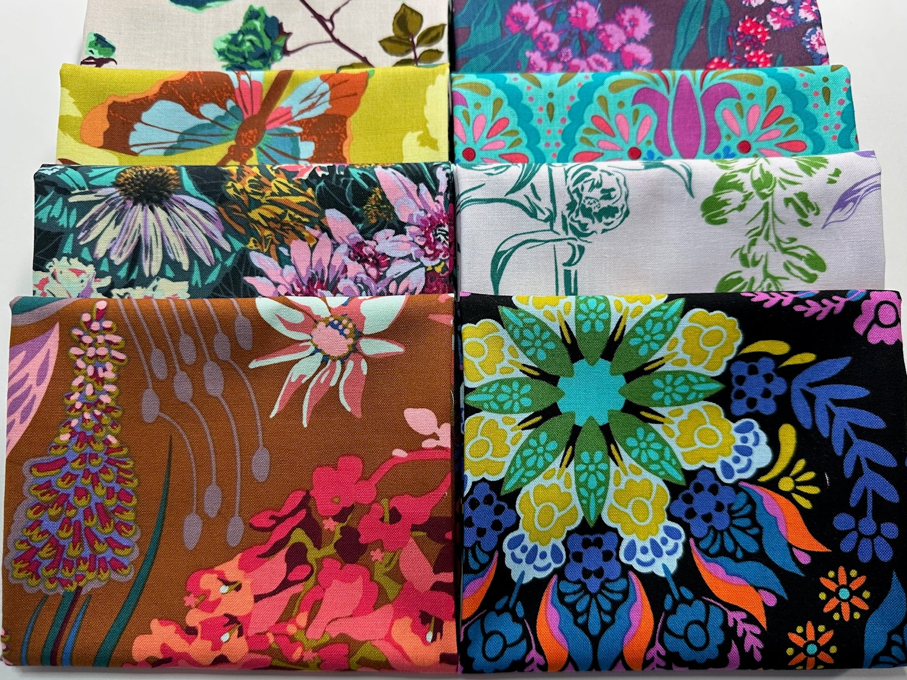 a collection of colorful fabric swatches, each with unique floral and abstract patterns.