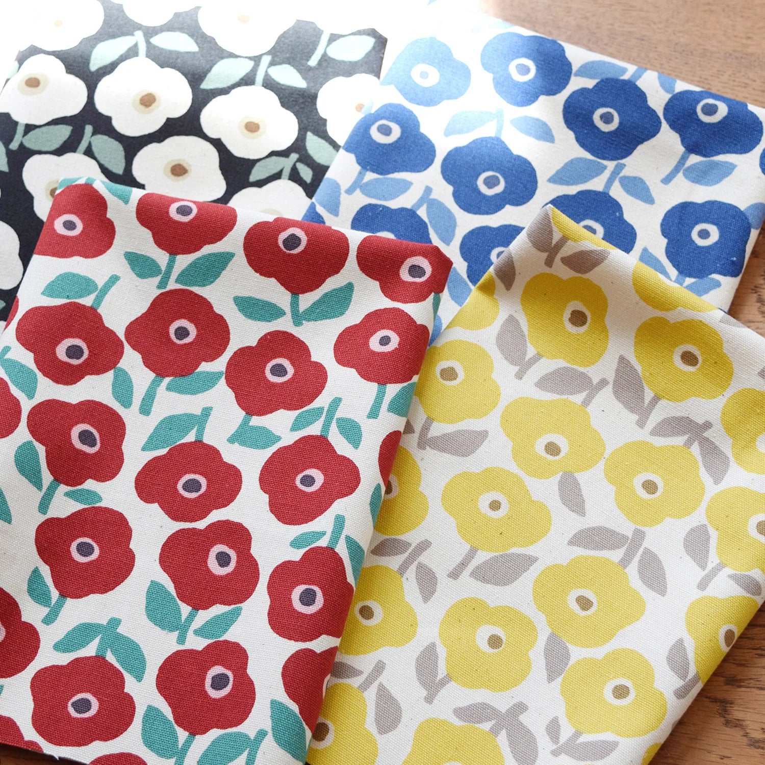 a collection of fabric swatches with various floral patterns, including red, blue, and yellow flowers.