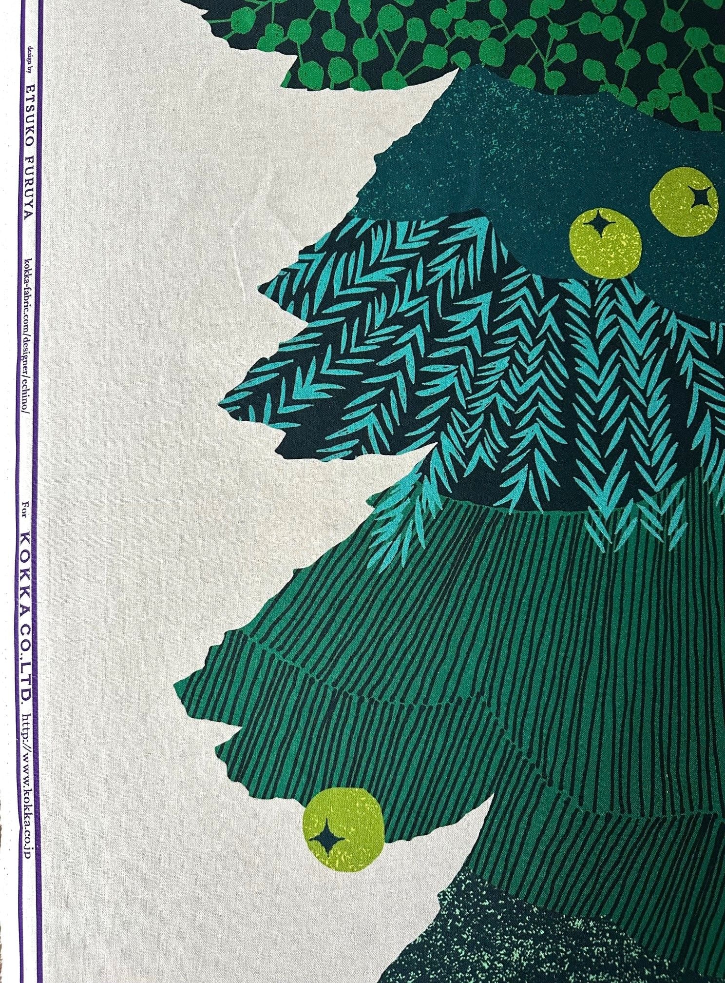 The image is a close-up of a Christmas tree with green and black stripes, and two yellow ornaments hanging from it.