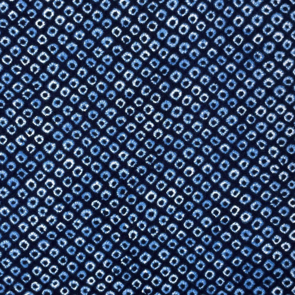 a close-up view of a fabric with a repeating pattern of small blue and white squares or dots, creating a visually striking and intricate design.