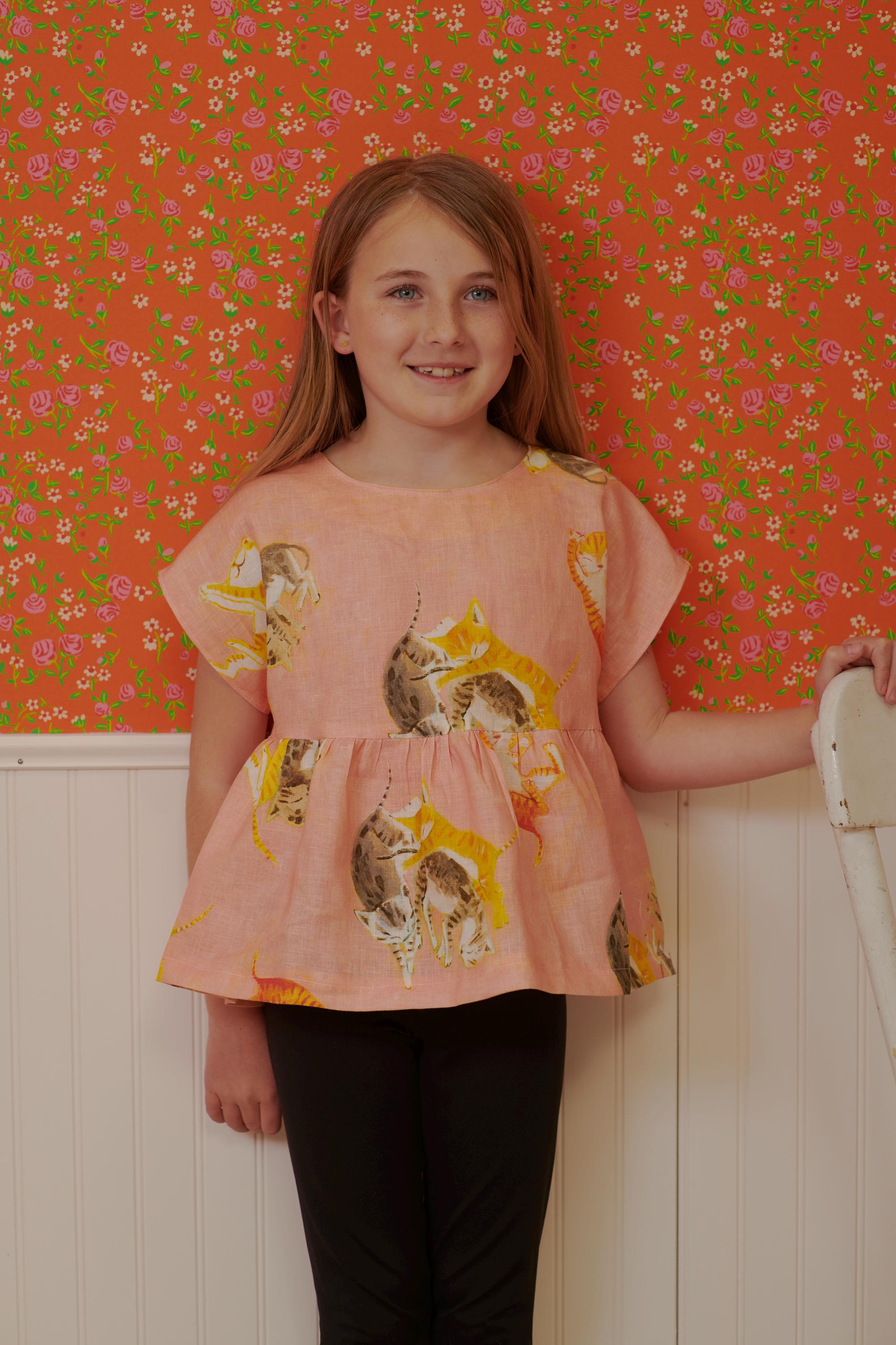 a little girl standing in front of a wall