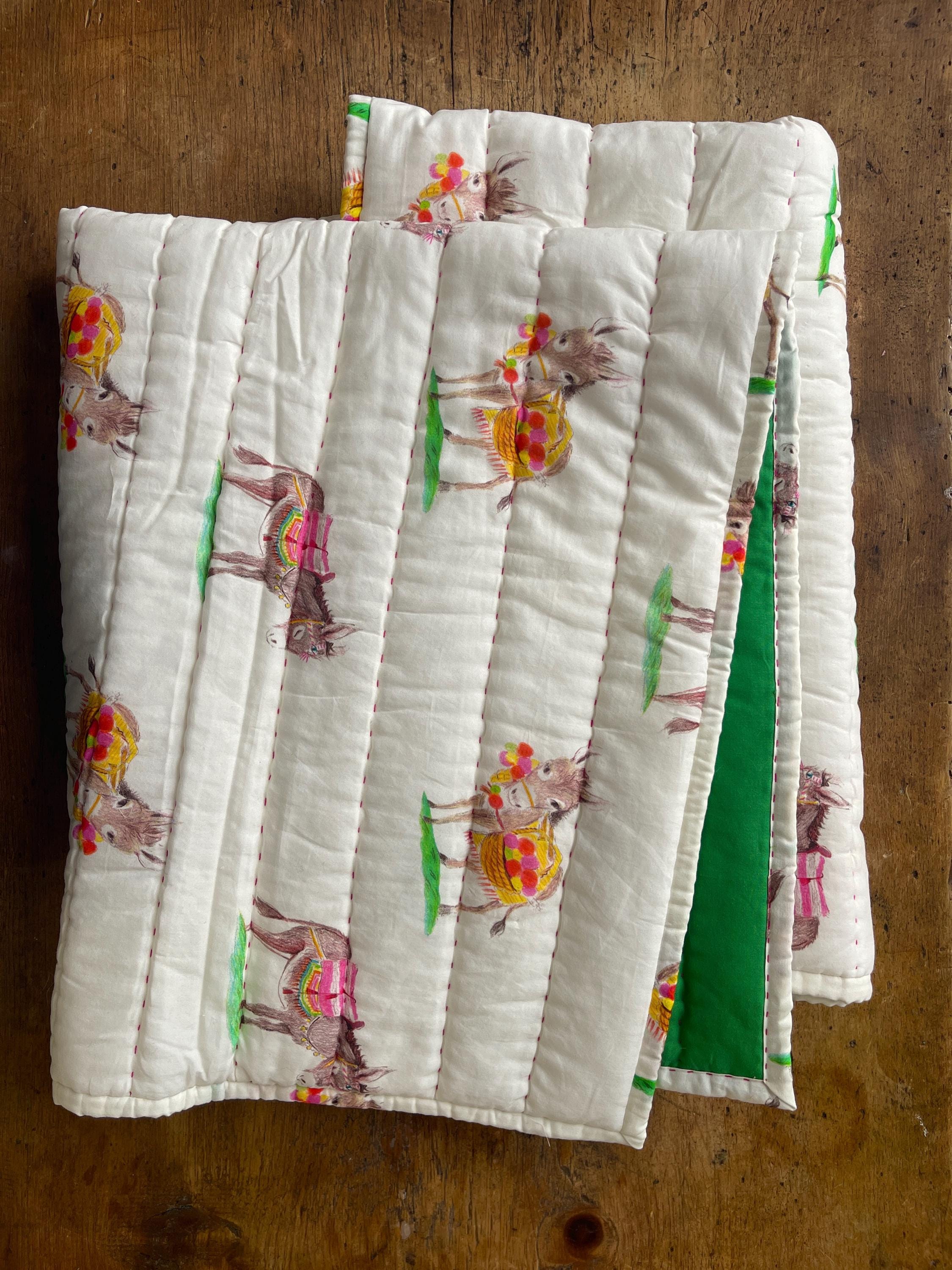a close up of two quilts on a table