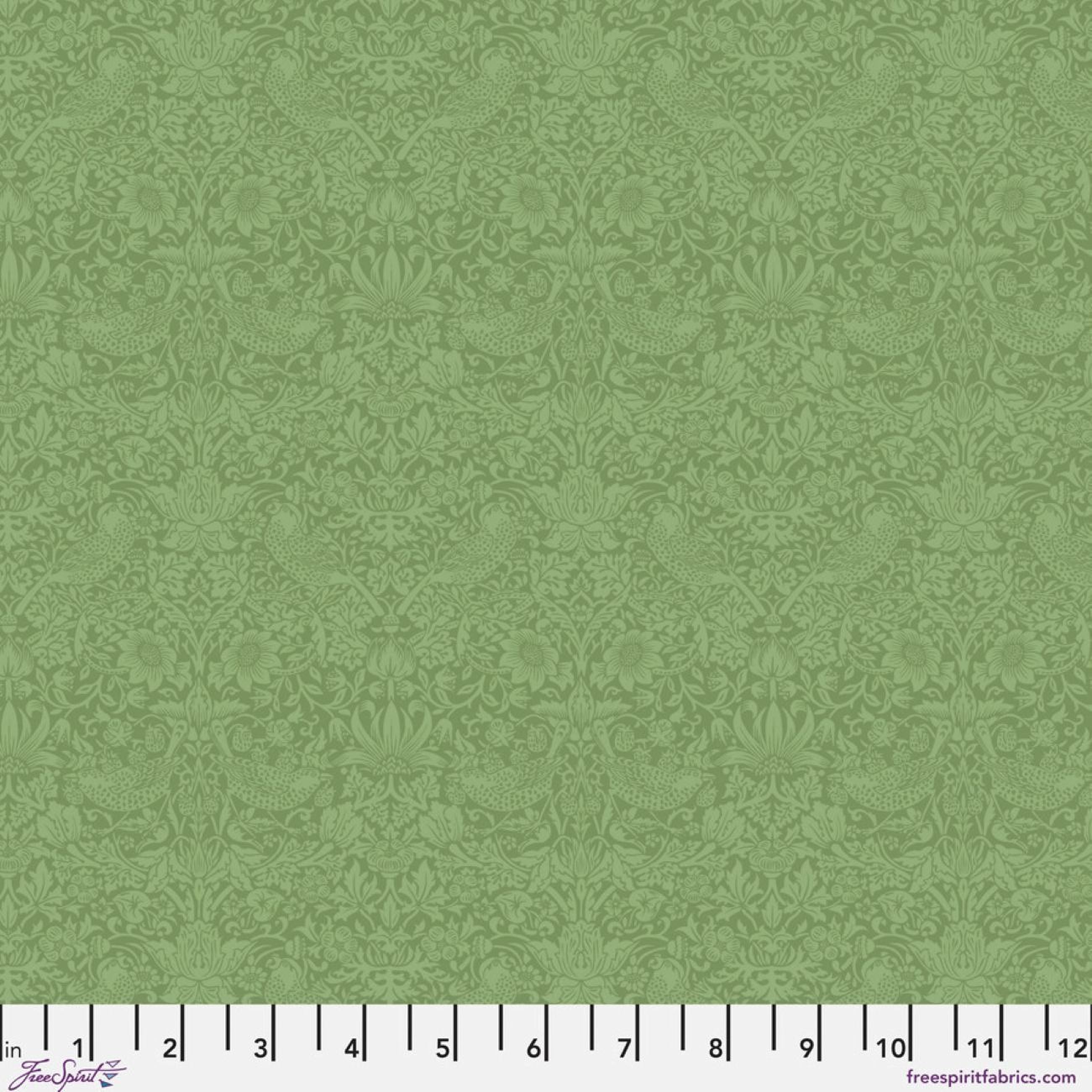 The image is a repeating pattern of green floral designs, with a ruler at the bottom indicating the size of the pattern in inches.
