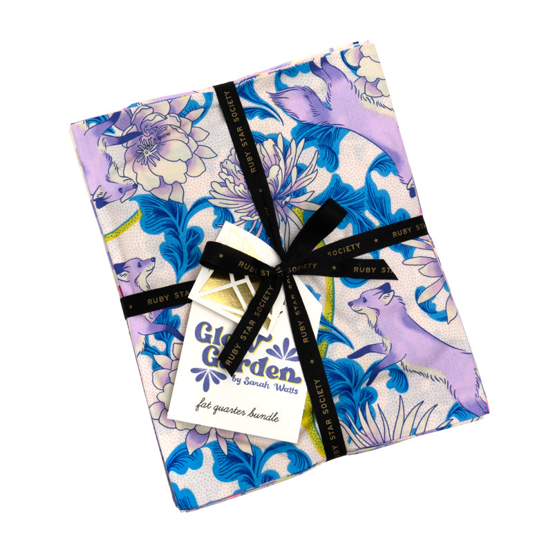 a square-shaped fabric with a floral pattern in shades of blue and purple, tied with a black ribbon.