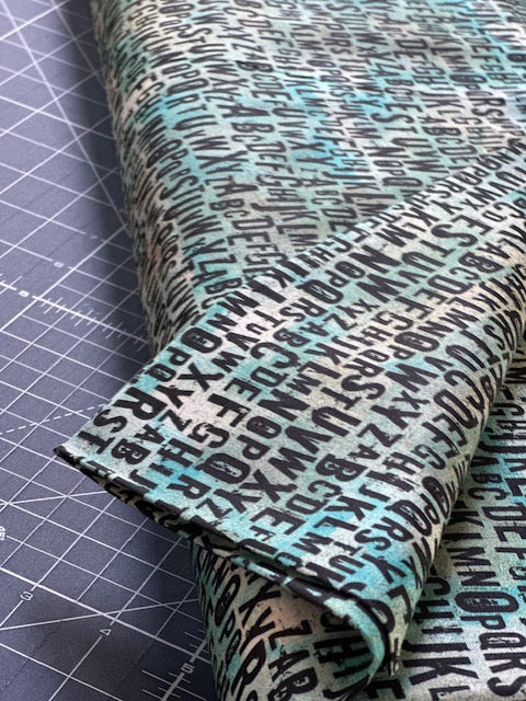 a close-up view of a fabric with a repeating pattern of black text and numbers, creating a textured and visually interesting surface.