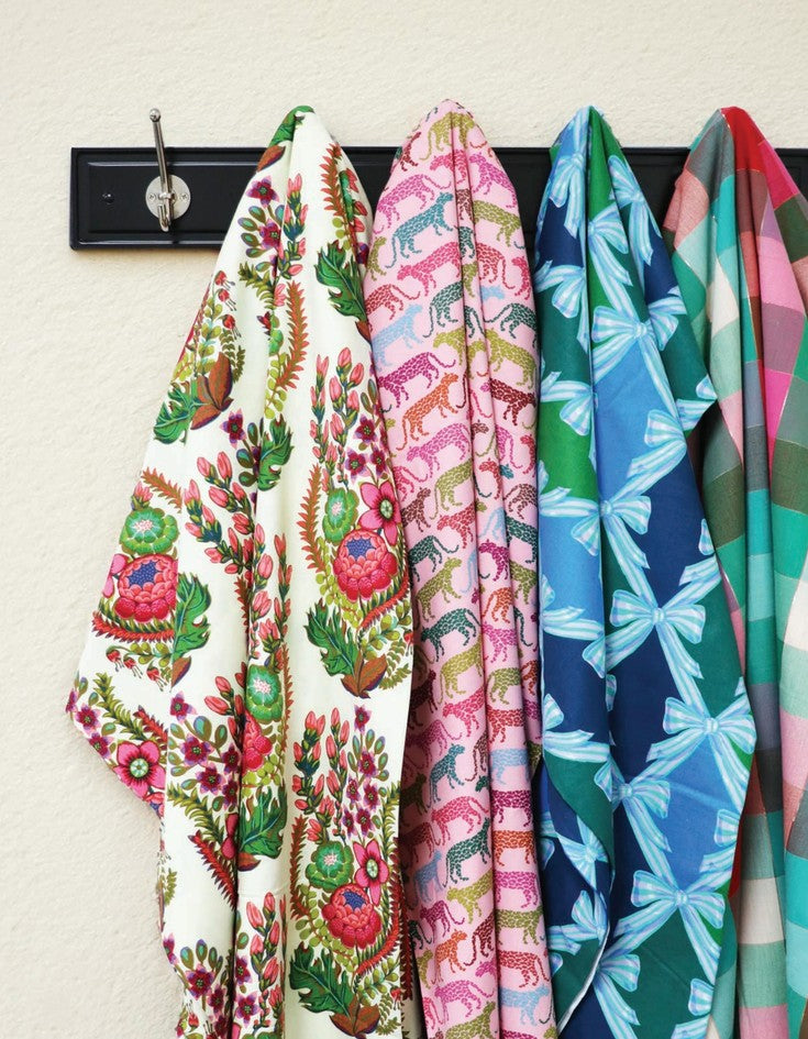 a collection of colorful, patterned fabric pieces hanging on a black coat rack.