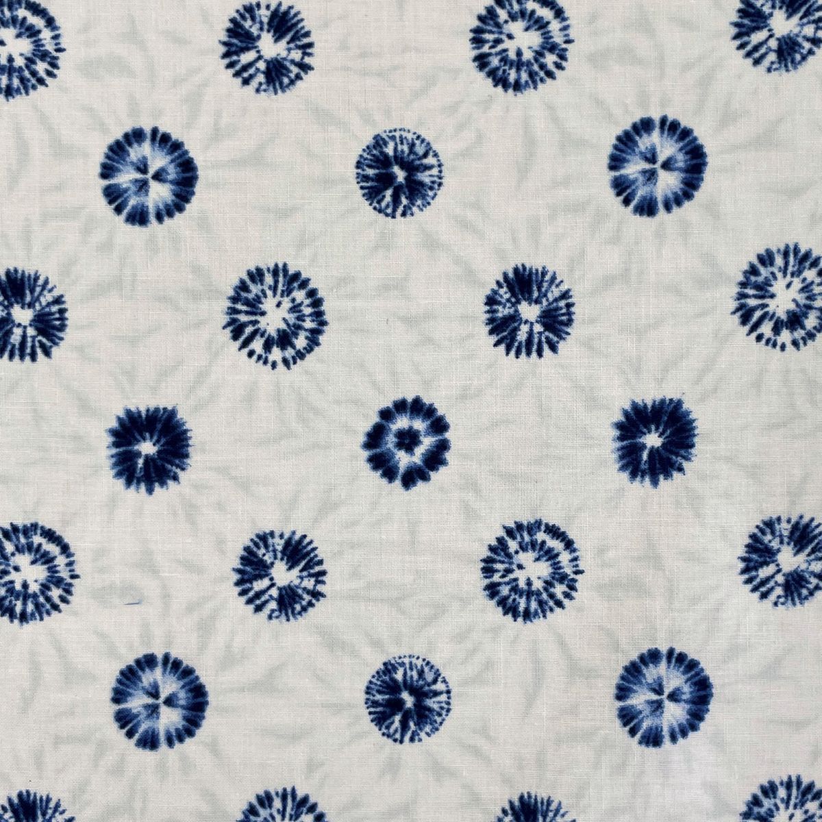 a repeating pattern of blue and white tie-dye flowers on a light-colored background.