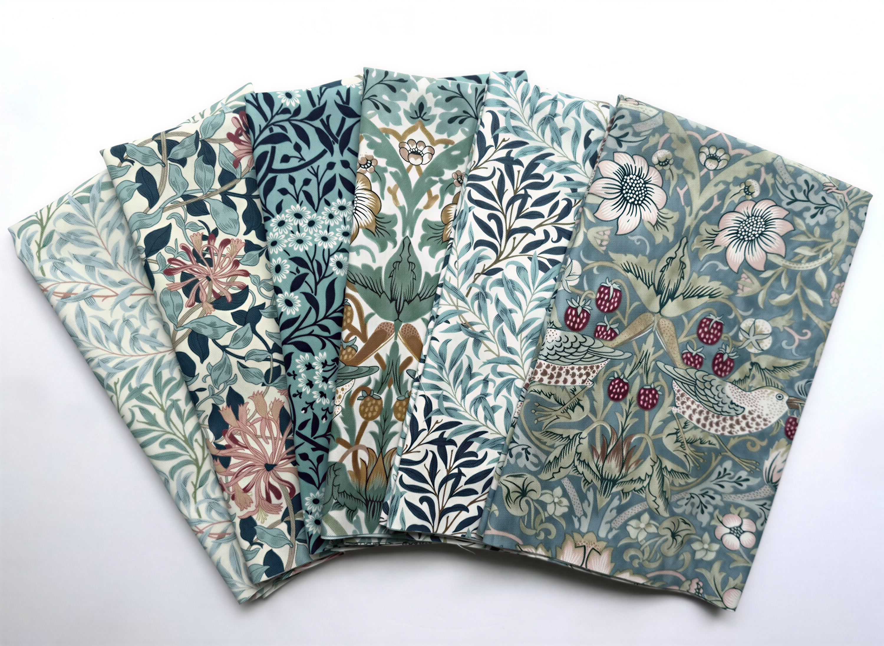 a collection of six fabric pieces with various floral and leaf patterns, arranged in a fan-like manner.