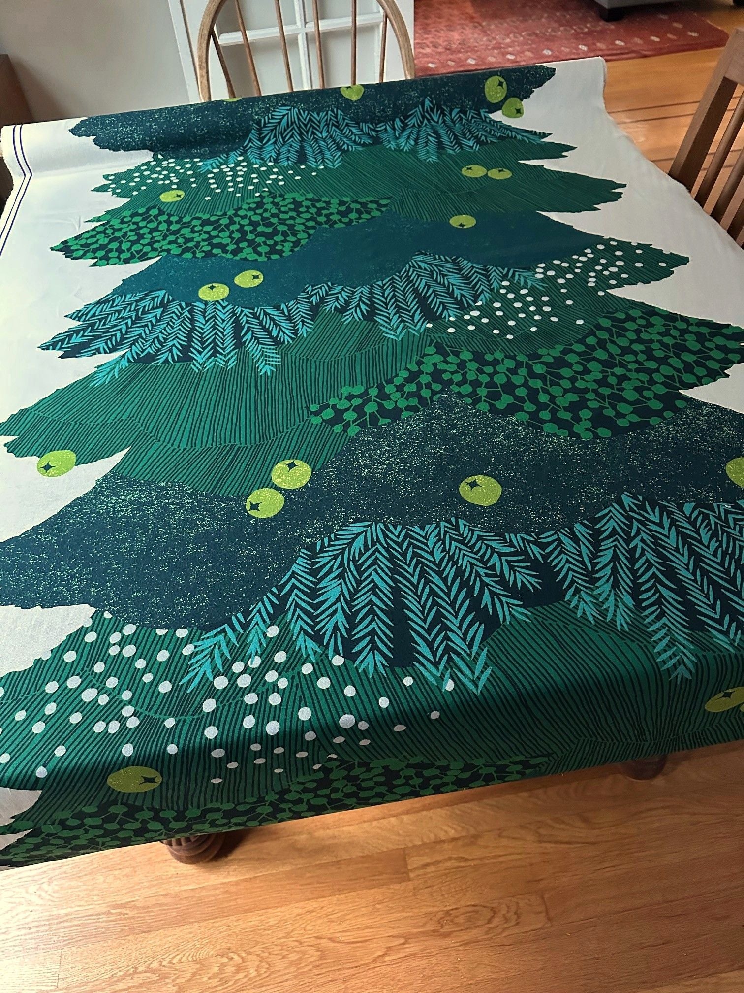 a table with a green and white patterned tablecloth, resembling a Christmas tree design.