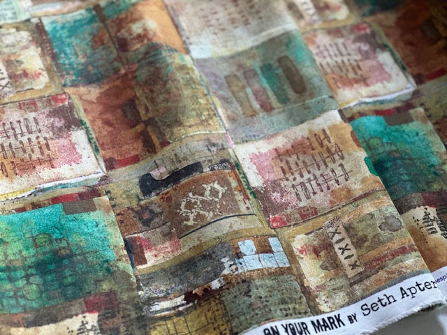 The image is a close-up of a fabric with a colorful, abstract pattern of various shapes and textures, including geometric shapes, organic forms, and a mix of warm and cool colors.