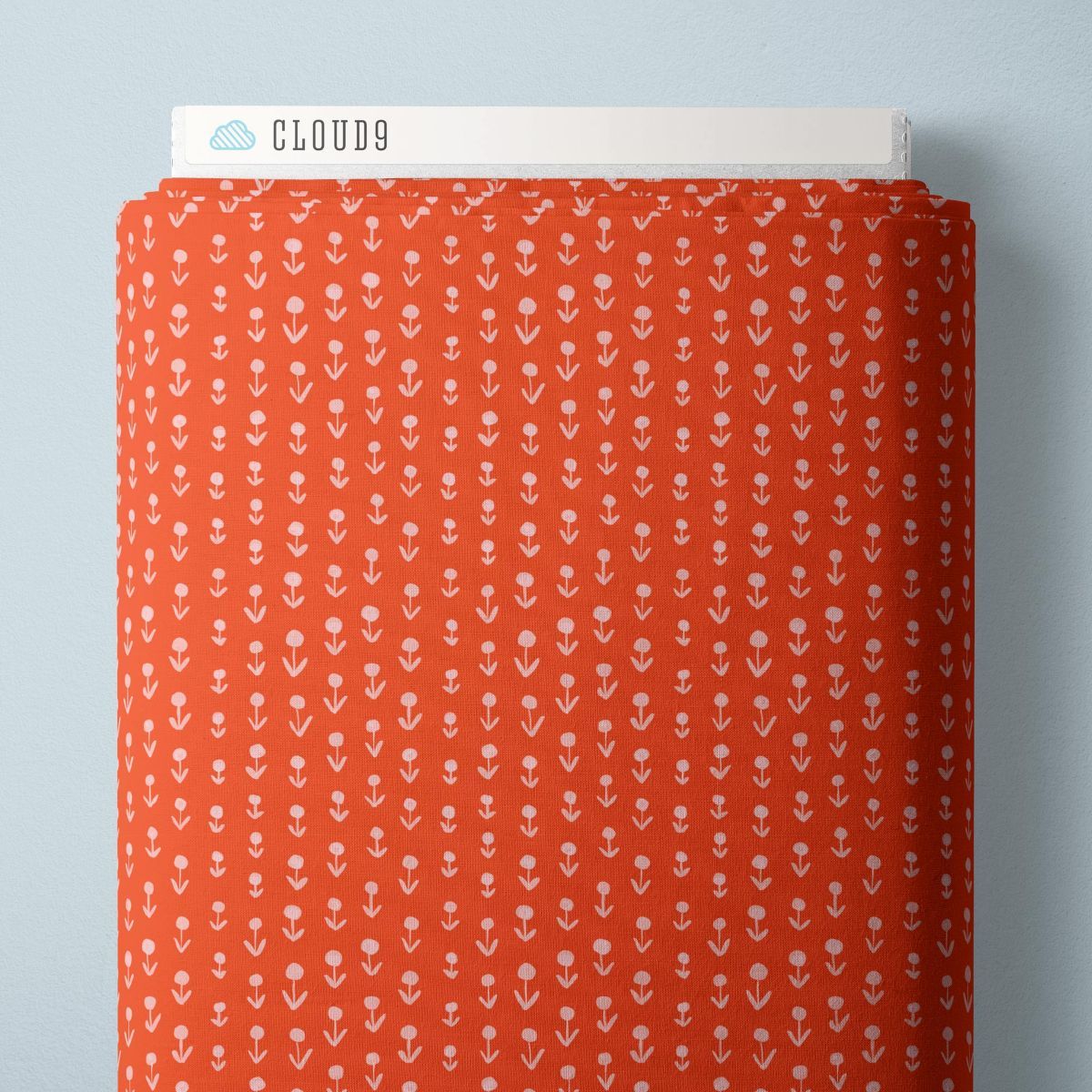 a red fabric with a repeating pattern of white flowers or leaves.