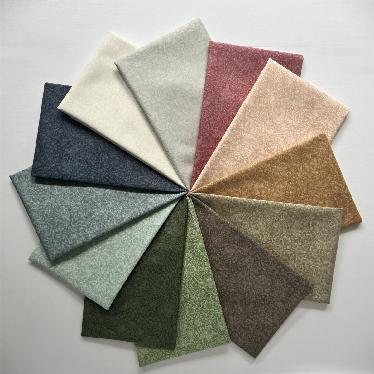 A collection of various fabric swatches in different colors and patterns, arranged in a circular pattern.