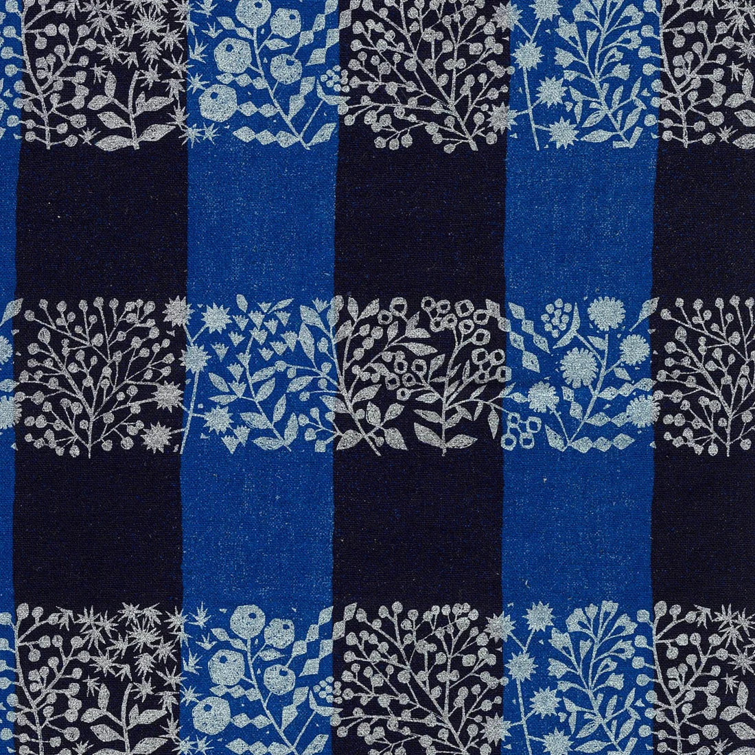 a pattern of blue and black squares with white floral and leaf designs.