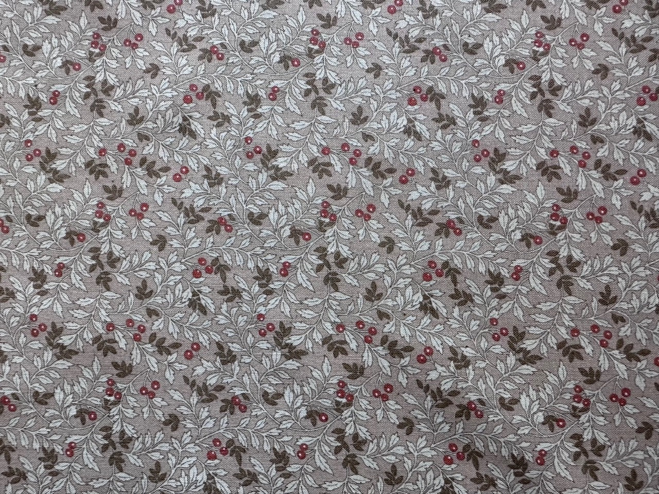 a repeating pattern of brown leaves with red berries on a beige background.
