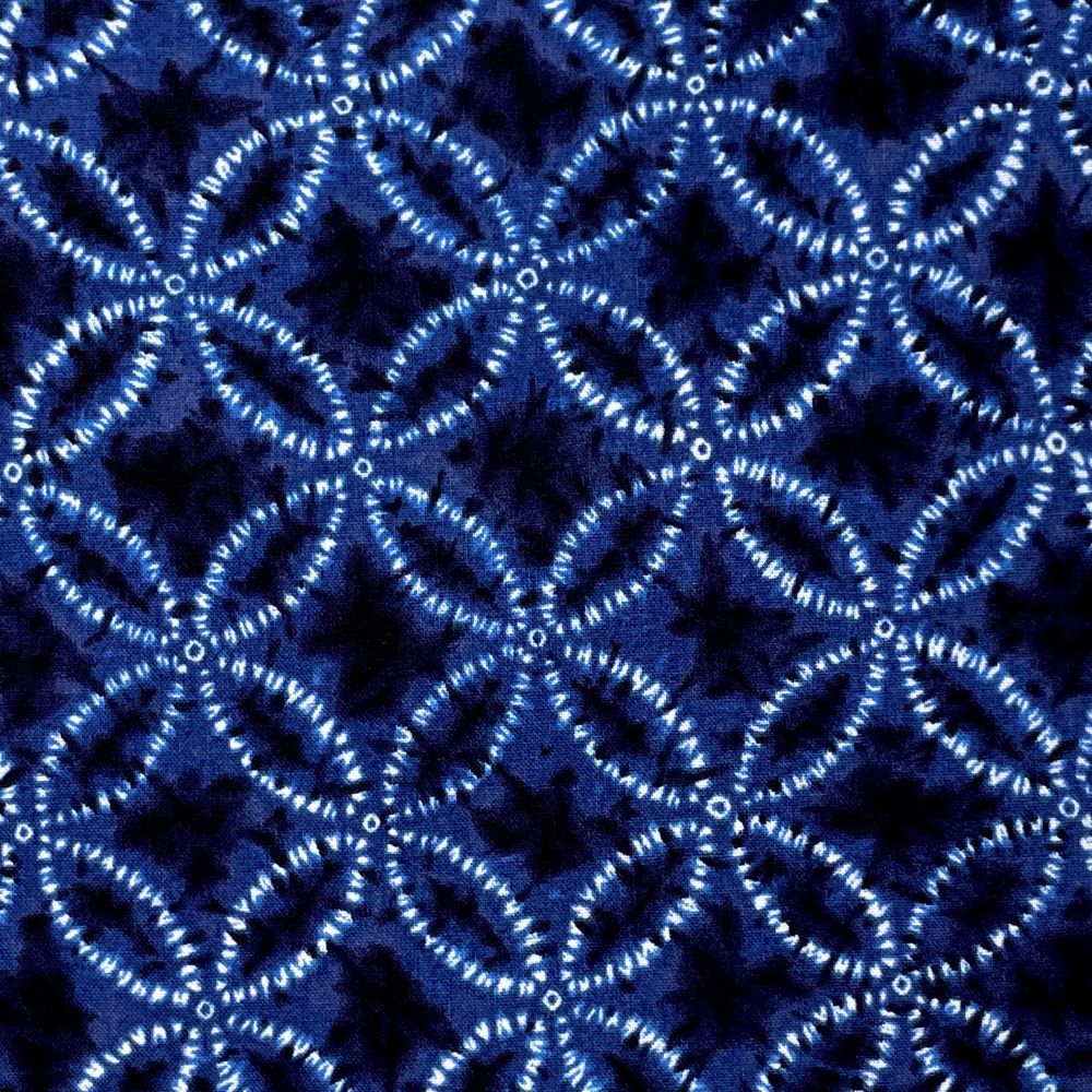 a close-up view of a fabric with a repeating pattern of blue and white circles and lines, creating a visually striking and intricate design.