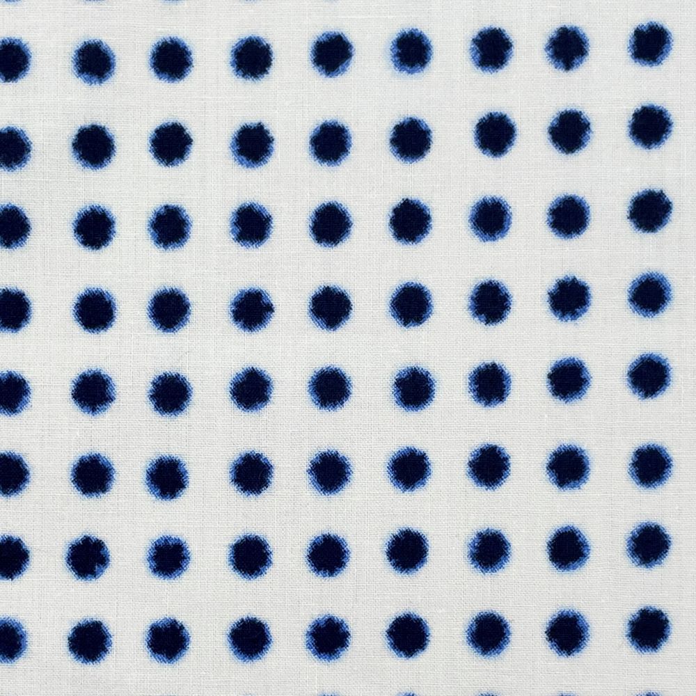 a close-up view of a fabric with a repeating pattern of blue dots on a white background.
