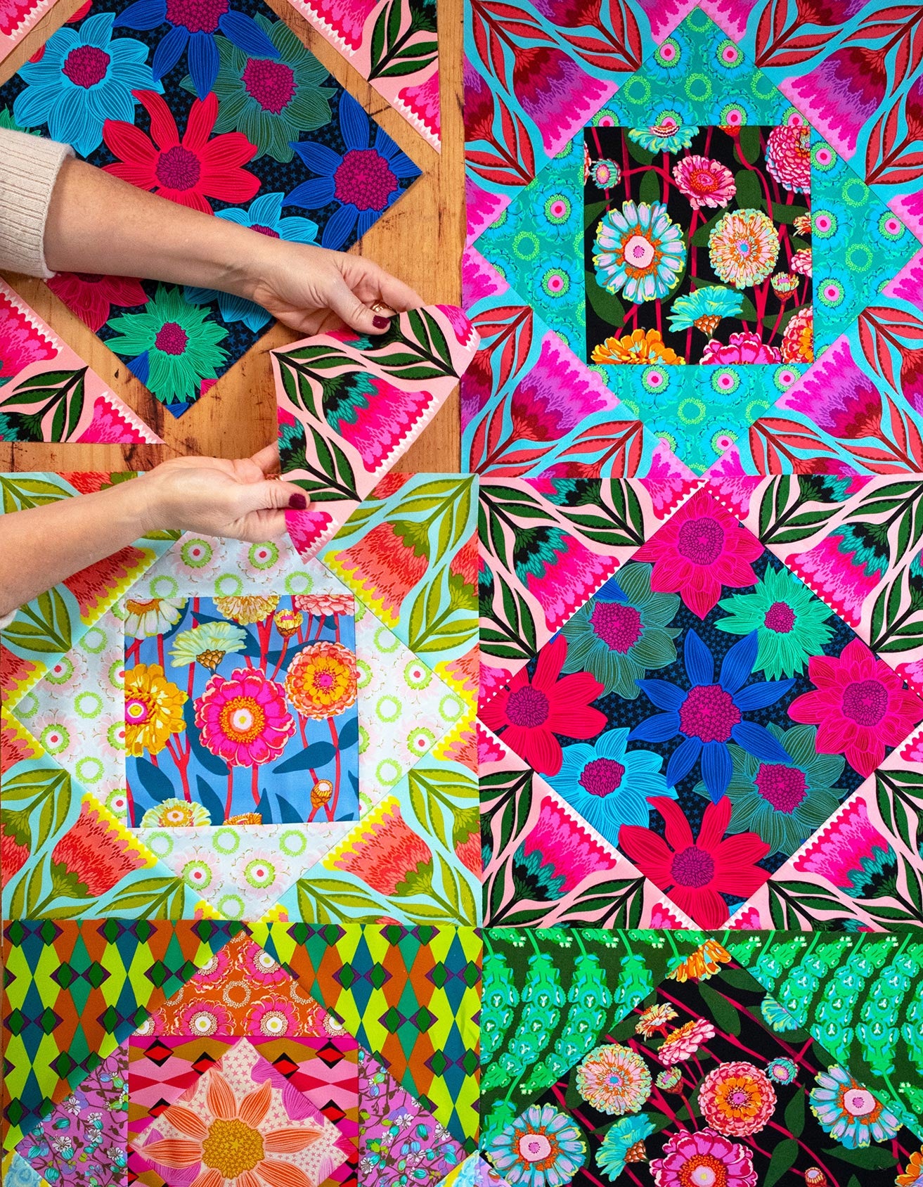 The image is a collage of various colorful and intricate floral patterns, with hands reaching out to touch the fabric.