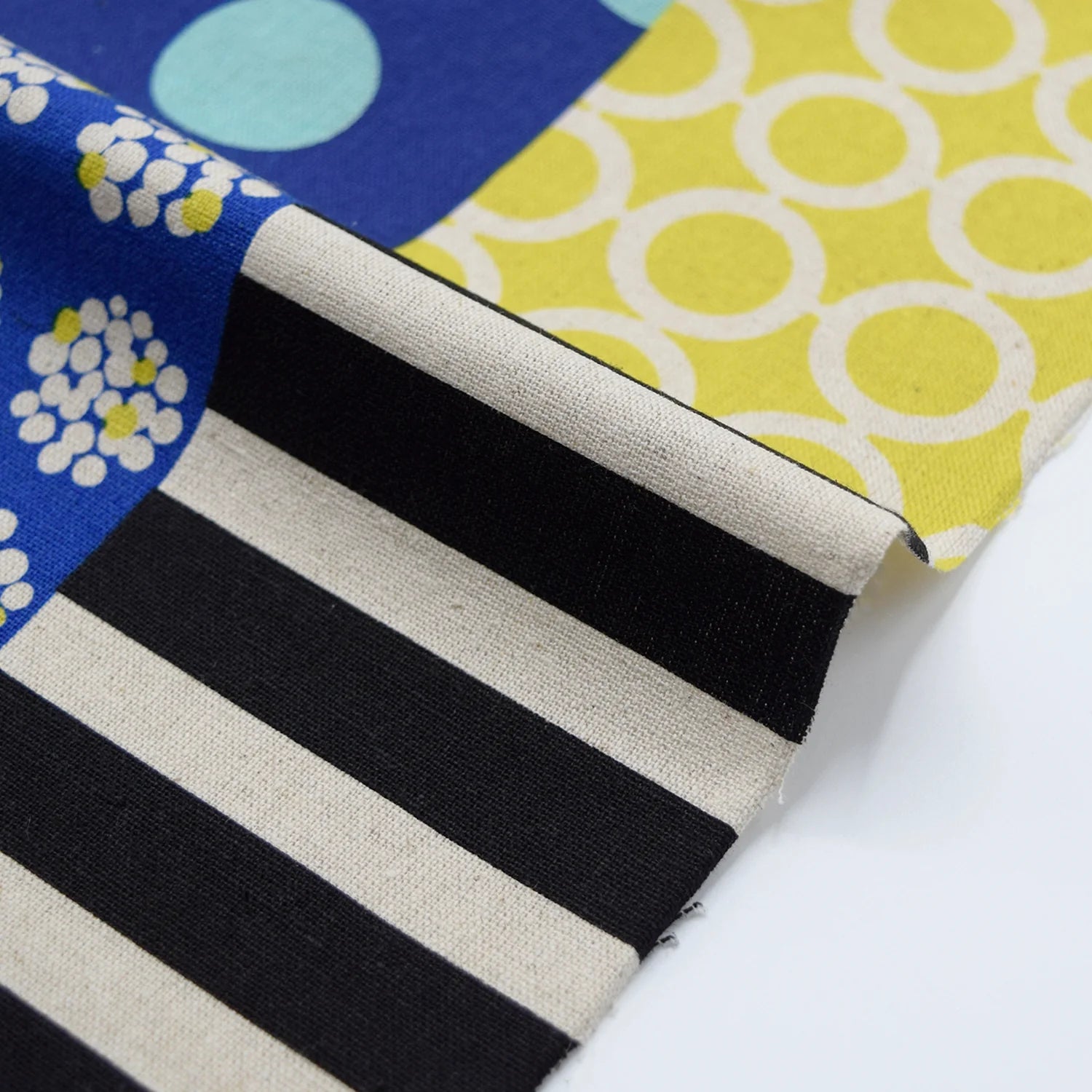 a close-up view of a fabric with a black and white striped pattern, along with a yellow and white circular pattern.