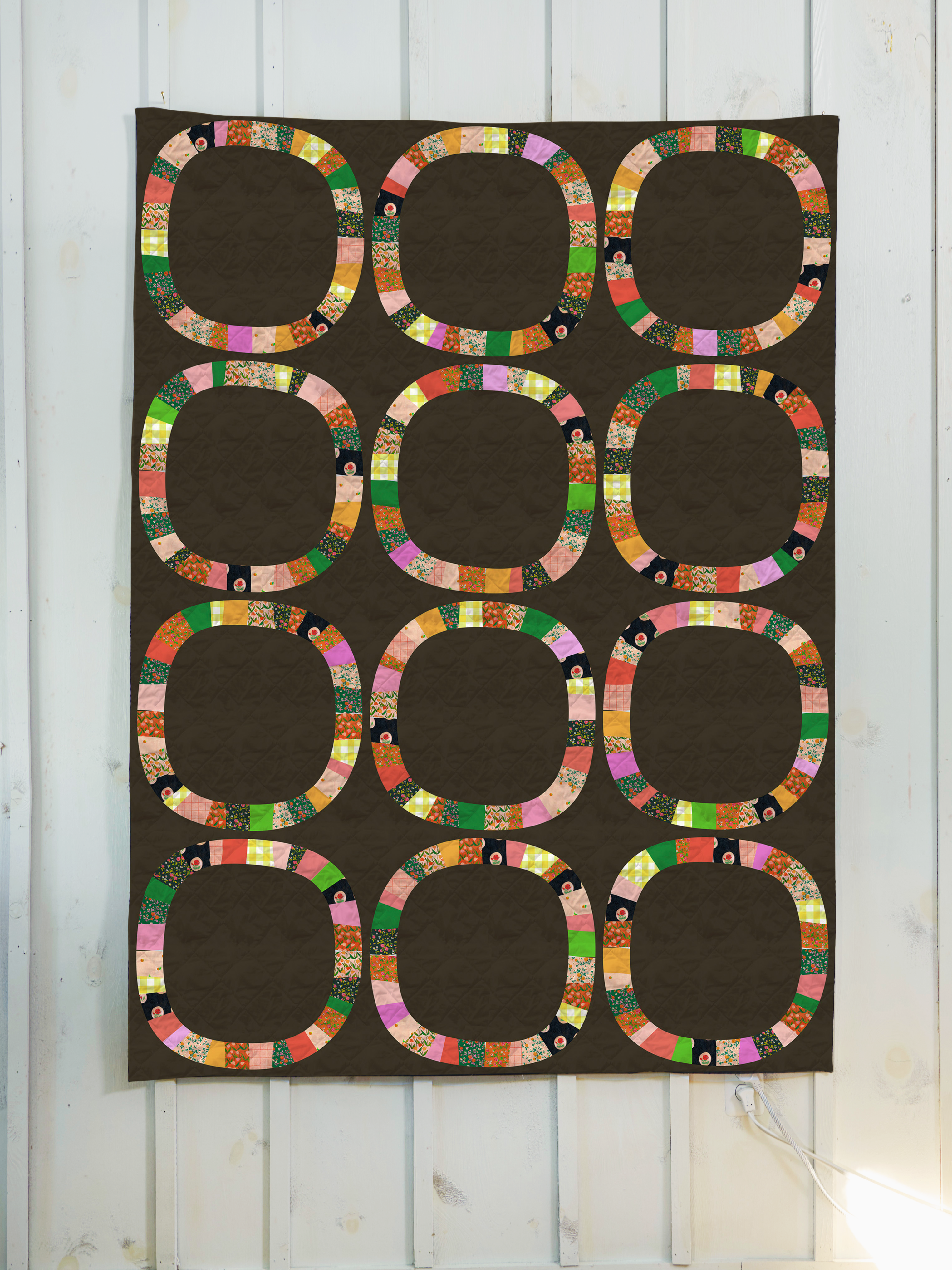a quilt hanging on a wall with circles on it