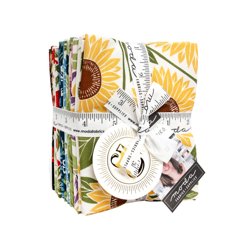 A bundle of fabric pieces with a sunflower pattern, tied together with a ribbon and a measuring tape.