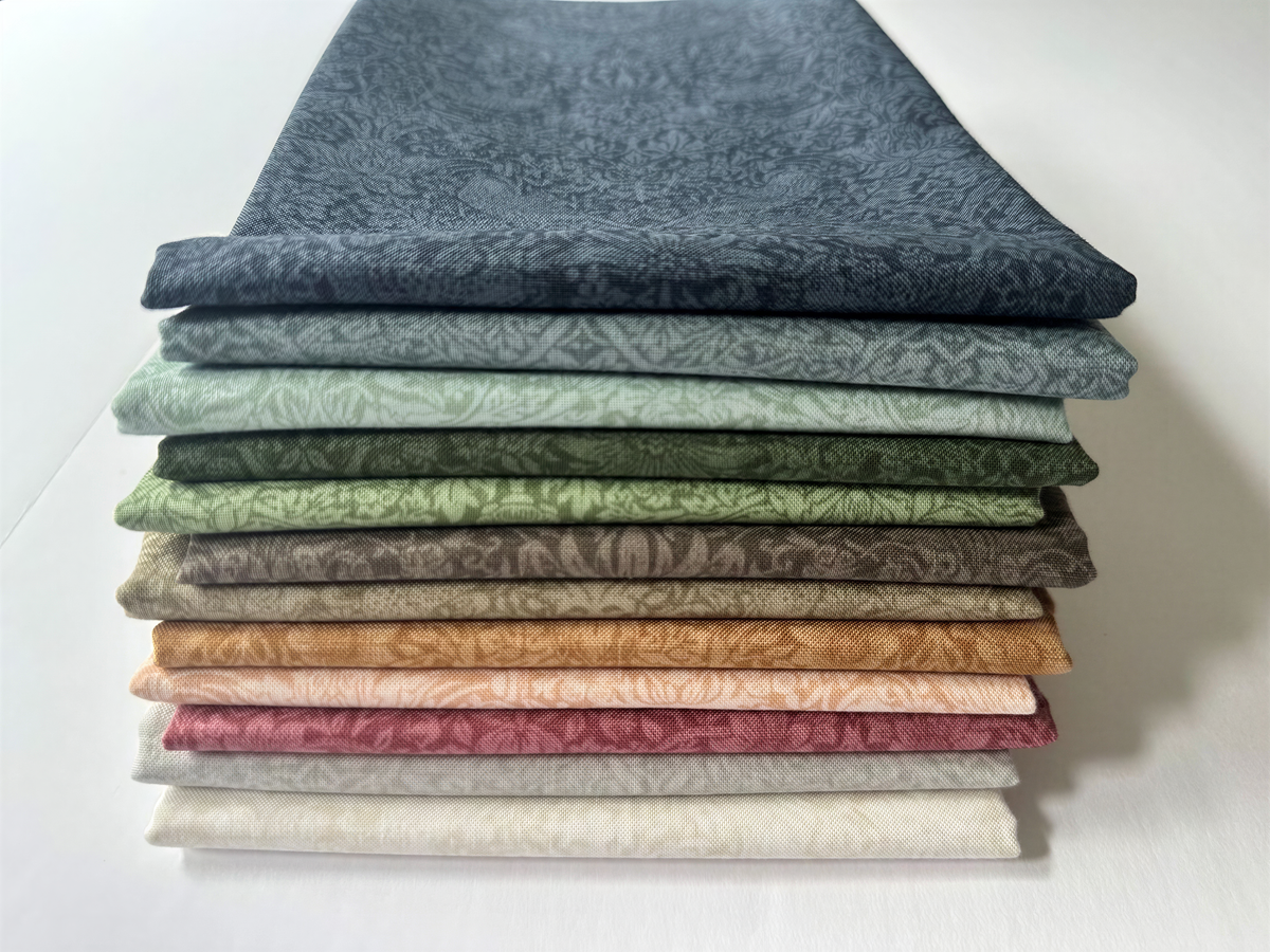A stack of nine fabric swatches in various colors and patterns, arranged in a visually appealing manner.